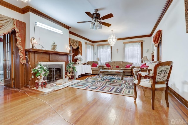 living room featuring baseboards, wood finished floors, a glass covered fireplace, and ornamental molding