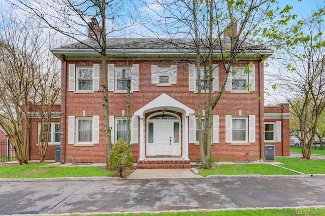 view of front of house featuring brick siding and a chimney