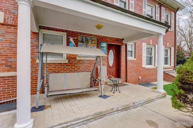 view of exterior entry featuring brick siding