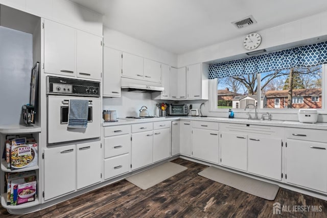 8 Martha Blvd, Sayreville, NJ 08879 - kitchen with white appliances, under cabinet range hood, light countertops, dark wood finished floors, and white cabinetry