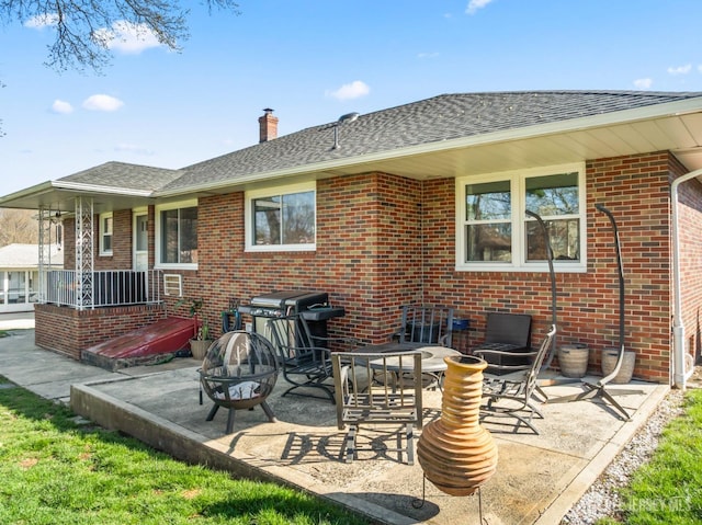 8 Martha Blvd, Sayreville, NJ 08879 - back of property featuring brick siding, a patio, a chimney, an outdoor fire pit, and a shingled roof