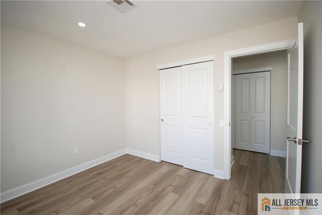 unfurnished bedroom with a closet and light hardwood / wood-style flooring