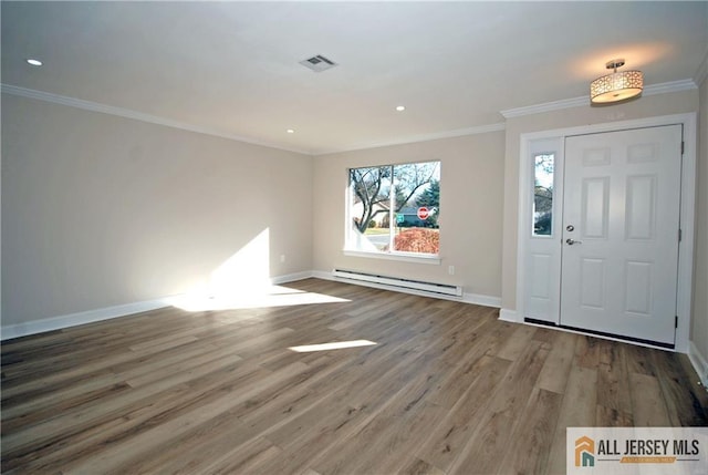 entryway with hardwood / wood-style flooring, a baseboard heating unit, a healthy amount of sunlight, and crown molding