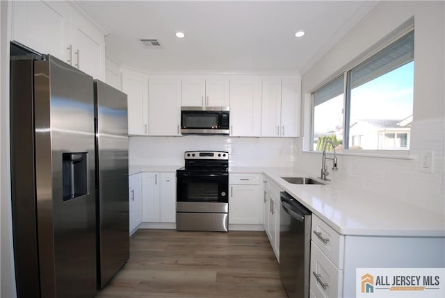 kitchen featuring stainless steel appliances, tasteful backsplash, dark hardwood / wood-style flooring, white cabinetry, and sink