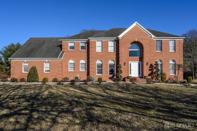 view of front of house with brick siding and a front yard