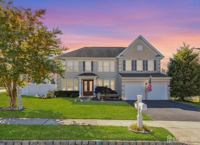 view of front of property featuring a yard, french doors, and a garage