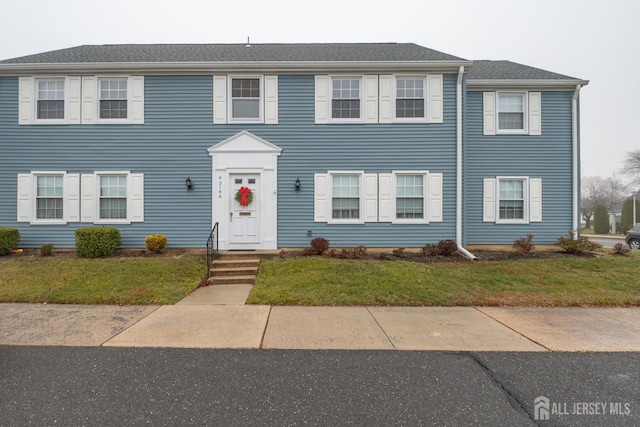 colonial inspired home with a front lawn