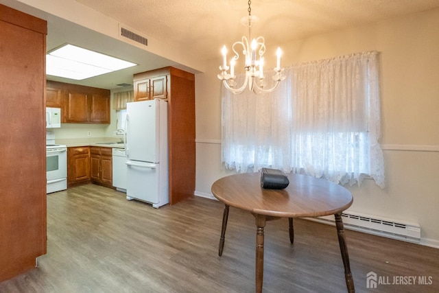 kitchen with sink, a chandelier, hanging light fixtures, white appliances, and a baseboard heating unit