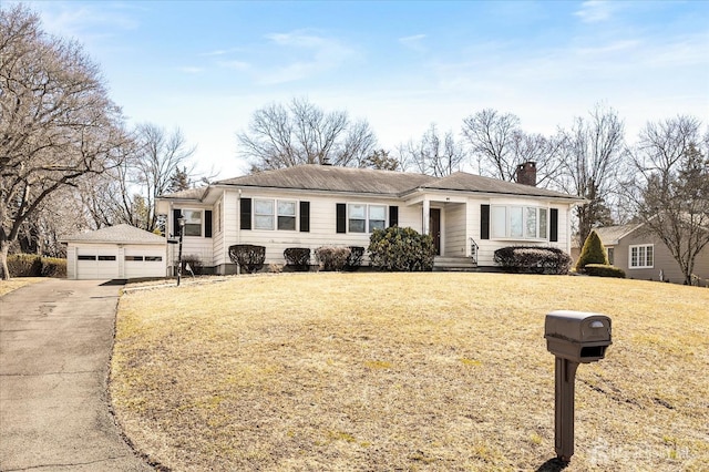 single story home featuring a detached garage, an outbuilding, a chimney, and a front lawn