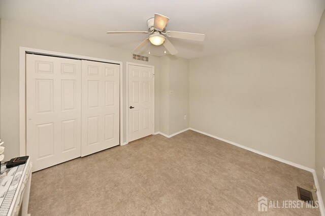 unfurnished bedroom featuring ceiling fan and light carpet