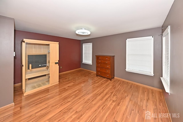 unfurnished bedroom with light wood-type flooring and baseboards