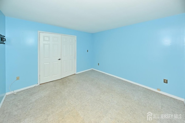 unfurnished bedroom featuring a closet and baseboards