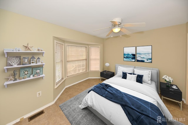 bedroom with carpet flooring, visible vents, baseboards, and ceiling fan