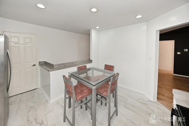 dining room with recessed lighting and baseboards