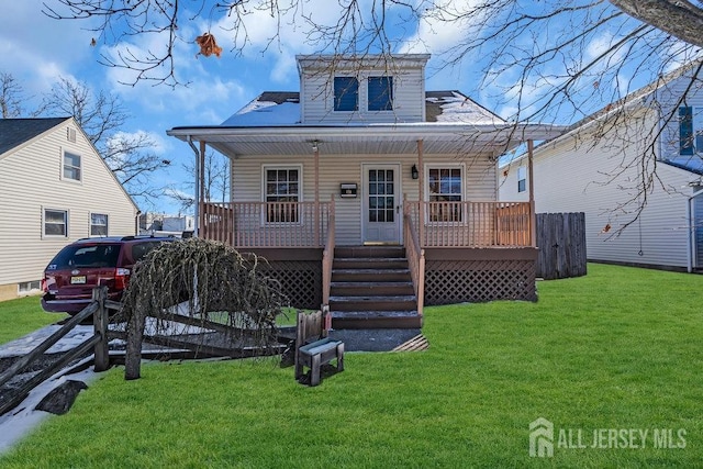 rear view of property with covered porch and a lawn