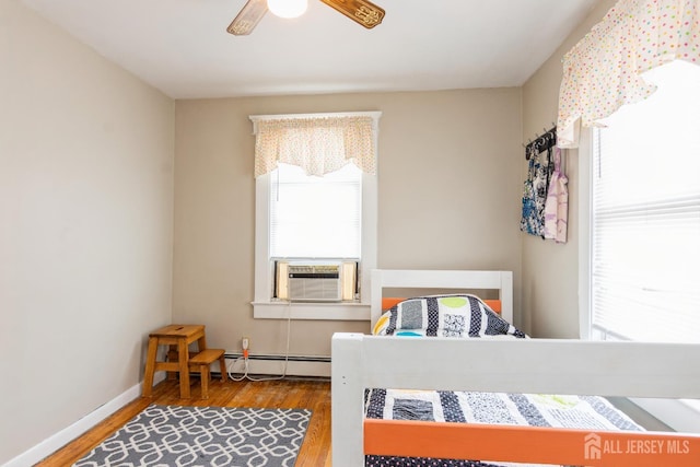 177 Hillside Ave, South River, NJ 08882 - bedroom with wood finished floors, cooling unit, ceiling fan, and a baseboard radiator