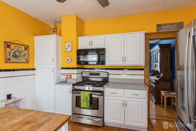 177 Hillside Ave, South River, NJ 08882 - kitchen with stainless steel appliances, white cabinets, tile walls, wood finished floors, and wainscoting