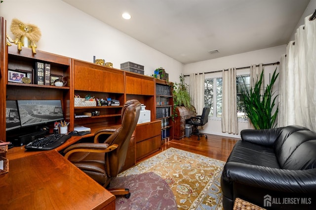 home office with recessed lighting, visible vents, lofted ceiling, and wood finished floors