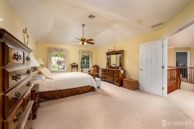 carpeted bedroom featuring lofted ceiling, visible vents, and a ceiling fan