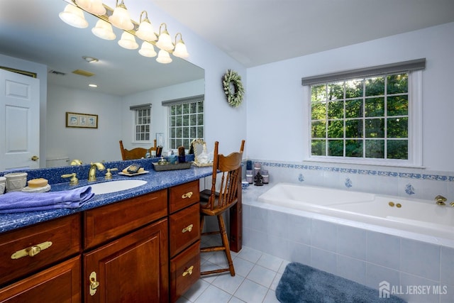 bathroom featuring visible vents, vanity, a bath, and tile patterned floors