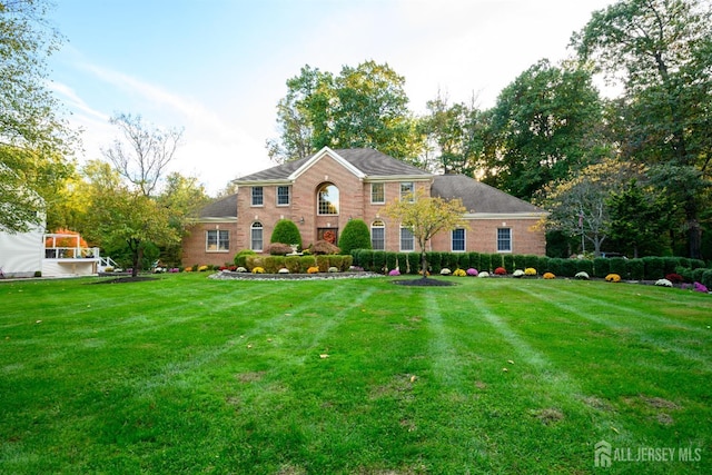 view of front facade featuring brick siding and a front lawn