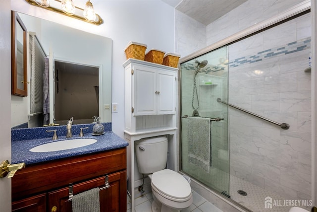 bathroom featuring toilet, a stall shower, and vanity