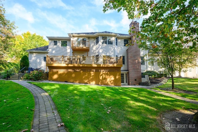 rear view of property with a balcony, a chimney, french doors, and a yard