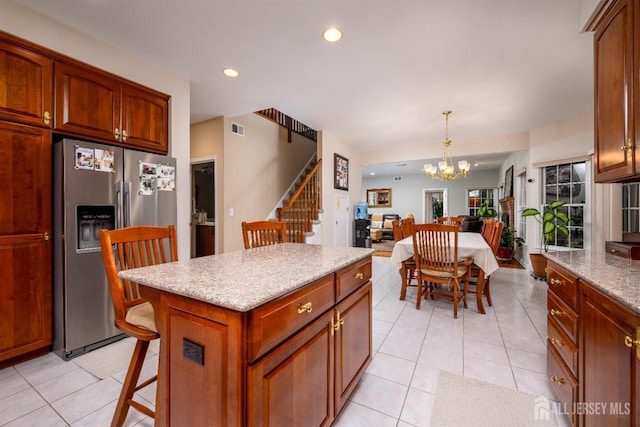 kitchen featuring light tile patterned floors, a breakfast bar, a chandelier, stainless steel refrigerator with ice dispenser, and recessed lighting