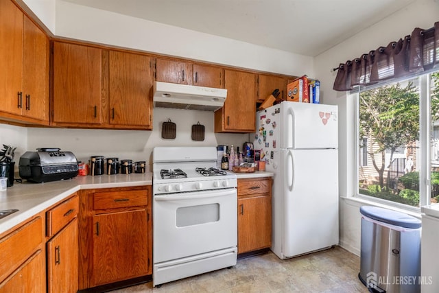 1103 Schmidt Ln, North Brunswick, NJ 08902 - kitchen featuring under cabinet range hood, white appliances, plenty of natural light, and light countertops