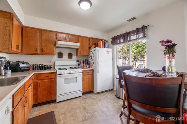 1103 Schmidt Ln, North Brunswick, NJ 08902 - kitchen with white appliances, under cabinet range hood, light countertops, and brown cabinets