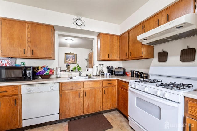 1103 Schmidt Ln, North Brunswick, NJ 08902 - kitchen featuring white appliances, under cabinet range hood, light countertops, and brown cabinets