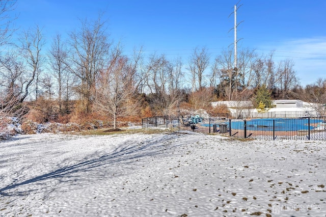 yard covered in snow with a covered pool