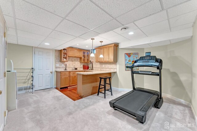 workout room featuring light carpet and sink