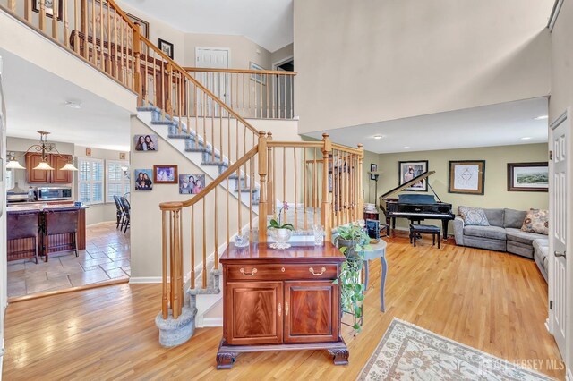 staircase with hardwood / wood-style floors and a high ceiling