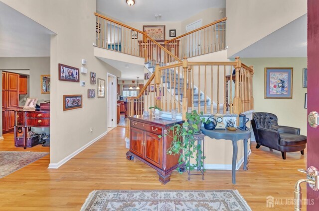 staircase featuring wood-type flooring and a high ceiling