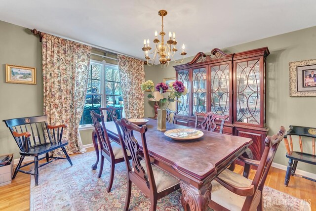 dining space featuring a notable chandelier and light hardwood / wood-style flooring