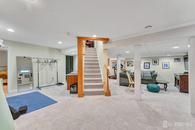 workout room with a paneled ceiling and light carpet