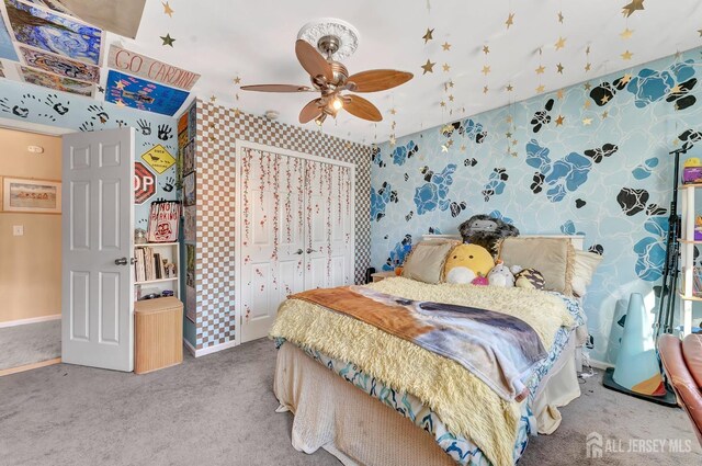 bedroom featuring ceiling fan, a closet, and carpet