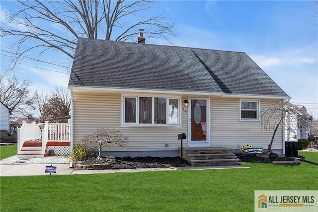 view of front of property with a deck, a front lawn, entry steps, a shingled roof, and a chimney