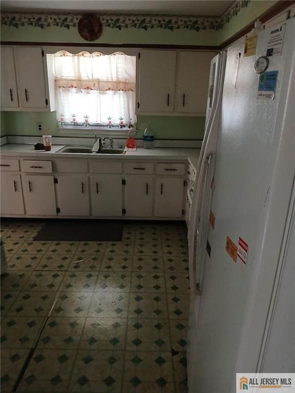 148 Dutton St, Franklin, NJ 08873 - kitchen featuring freestanding refrigerator, white cabinets, light countertops, and tile patterned floors