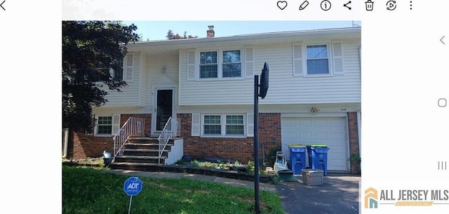 148 Dutton St, Franklin, NJ 08873 - raised ranch with brick siding, an attached garage, and a chimney