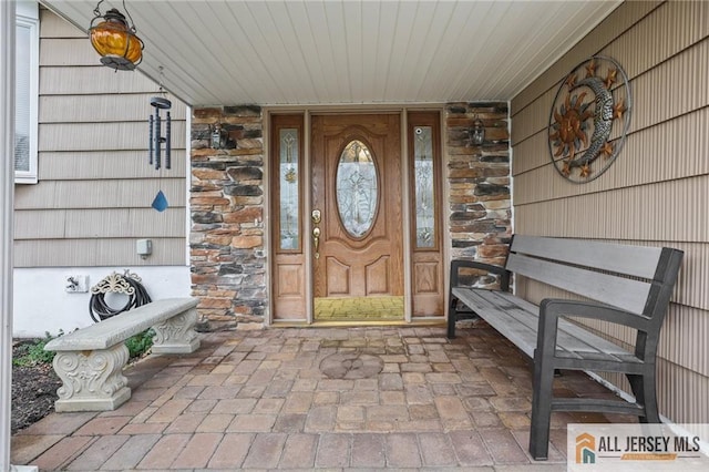 7 Piedmont Dr, Old Bridge, NJ 08857 - doorway to property featuring stone siding and covered porch