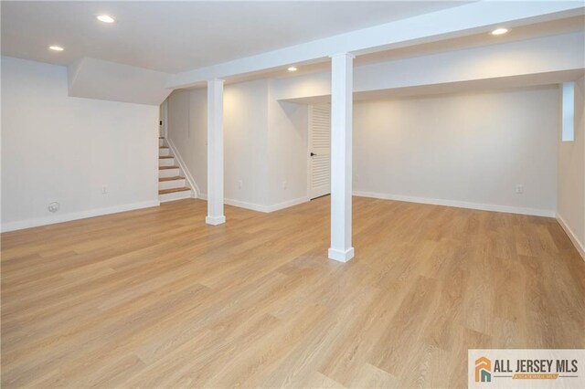 finished basement featuring stairs, recessed lighting, baseboards, and light wood finished floors
