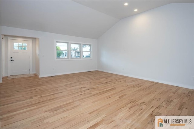 unfurnished living room with lofted ceiling, light wood finished floors, healthy amount of natural light, recessed lighting, and baseboards