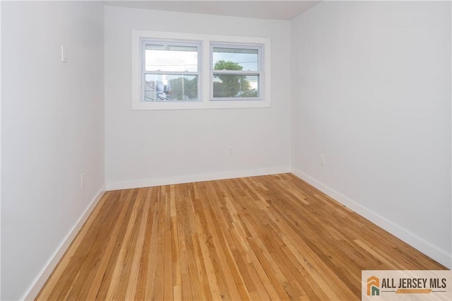 spare room with light wood-style flooring and baseboards