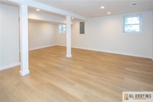 basement with electric panel, baseboards, recessed lighting, and light wood finished floors