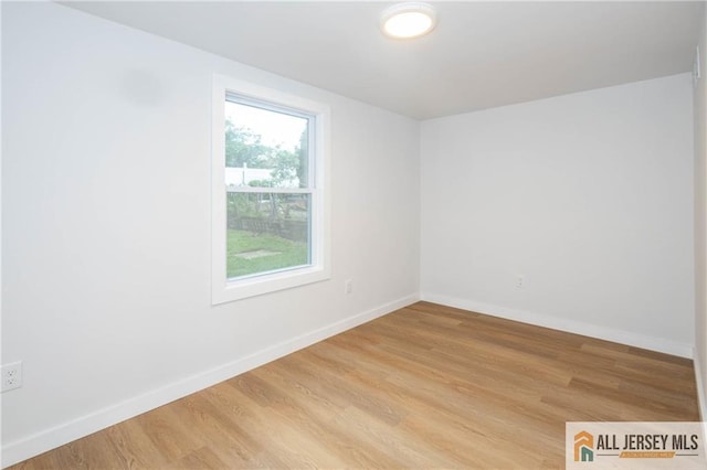 spare room featuring light wood-style floors and baseboards