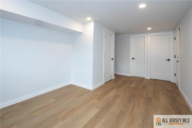 below grade area with light wood finished floors, baseboards, and recessed lighting