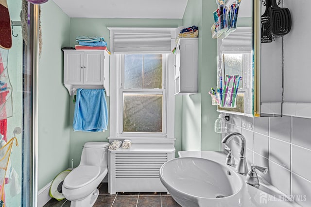 55 Suydam St, New Brunswick, NJ 08901 - bathroom with a sink, toilet, tile patterned floors, radiator heating unit, and tasteful backsplash