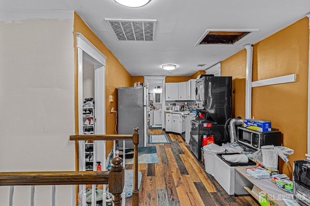 55 Suydam St, New Brunswick, NJ 08901 - kitchen with appliances with stainless steel finishes, white cabinetry, dark wood-type flooring, and light countertops